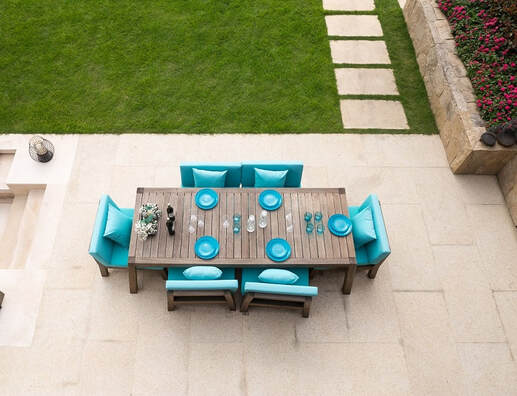 A concrete patio with outdoor dining table and concrete walkway on green grass